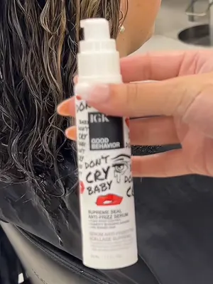 Raw footage: stylist holding up a bottle of anti-frizz serum