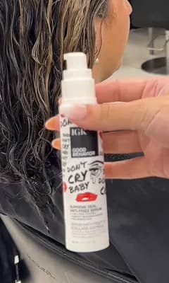 Raw footage: stylist holding up a bottle of anti-frizz serum