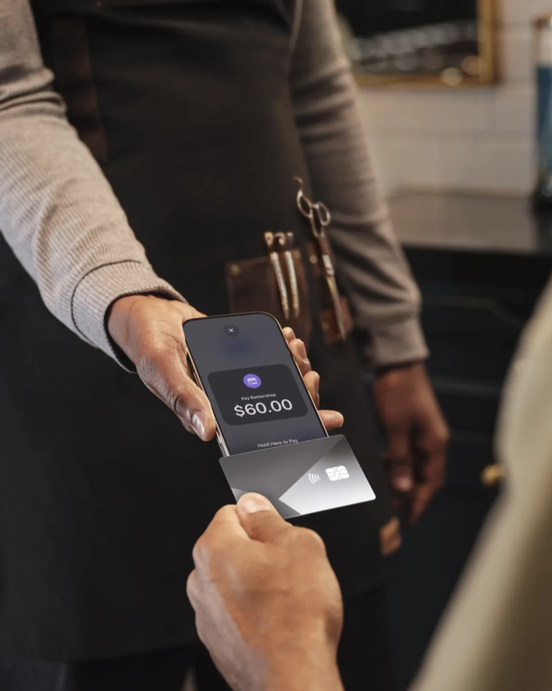 Client tapping a card on a barber’s iPhone to pay $60 with Tap to Pay
